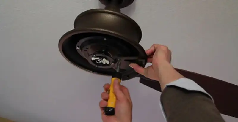 Electrician installing ceiling fan mounting bracket and fixture in Baton Rouge, LA