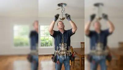 Electrician wiring a chandelier to a reinforced ceiling brace in Baton Rouge, LA