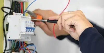 Electrician installing and adjusting circuit breakers in an electrical panel in Baton Rouge, LA