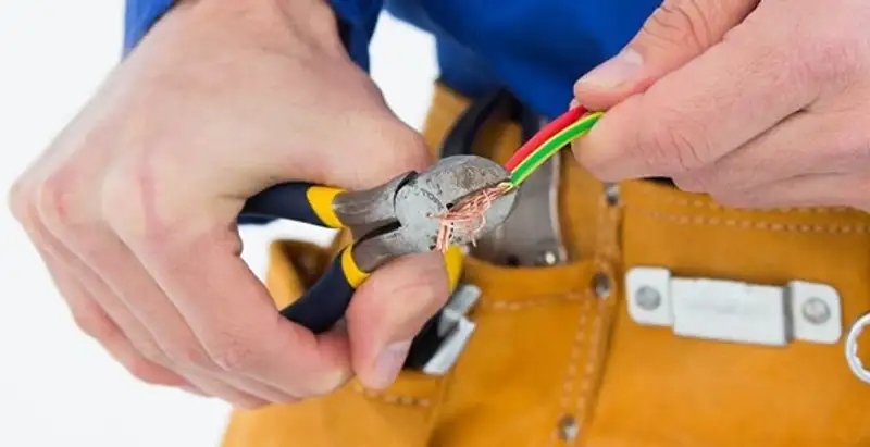 licensed electrician securing electrical wiring with professional tools during service work in Baton Rouge, LA