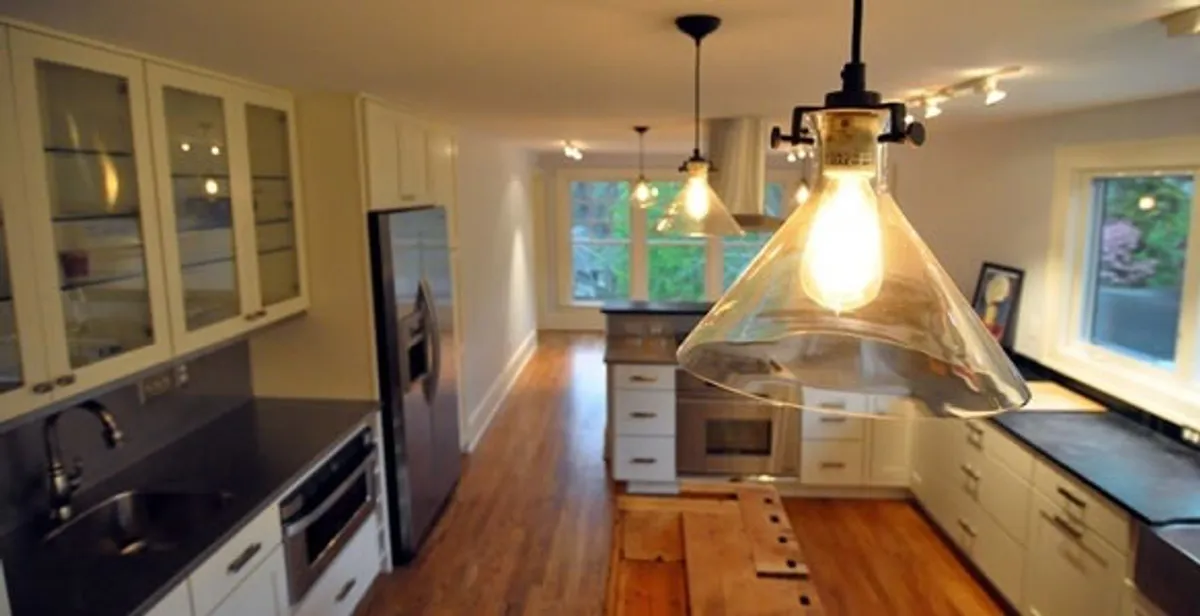 Residential electrician installing modern indoor light fixture in a home in Baton Rouge, LA
