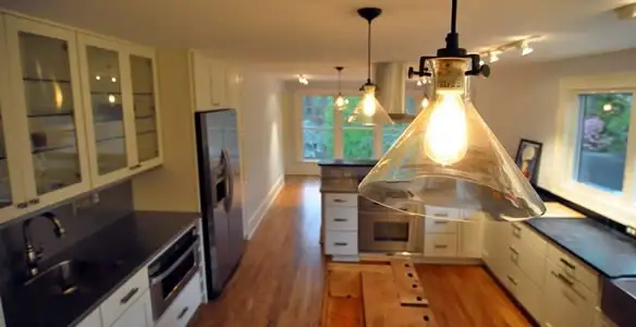 Residential electrician installing modern indoor light fixture in a home in Baton Rouge, LA